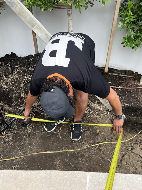 JB crew member measuring a garden bed during the Melbourne tree relocation assessment